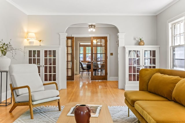 2901 Vincent Ave N, Minneapolis, MN 55411 - living area with arched walkways, french doors, ornate columns, light wood-style flooring, and crown molding