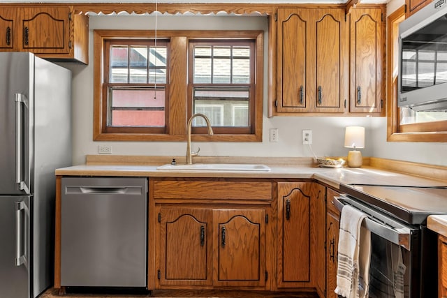 2901 Vincent Ave N, Minneapolis, MN 55411 - kitchen featuring stainless steel appliances, a sink, brown cabinets, and light countertops