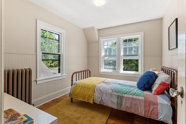 2901 Vincent Ave N, Minneapolis, MN 55411 - bedroom featuring radiator heating unit, wood finished floors, a wainscoted wall, and baseboards