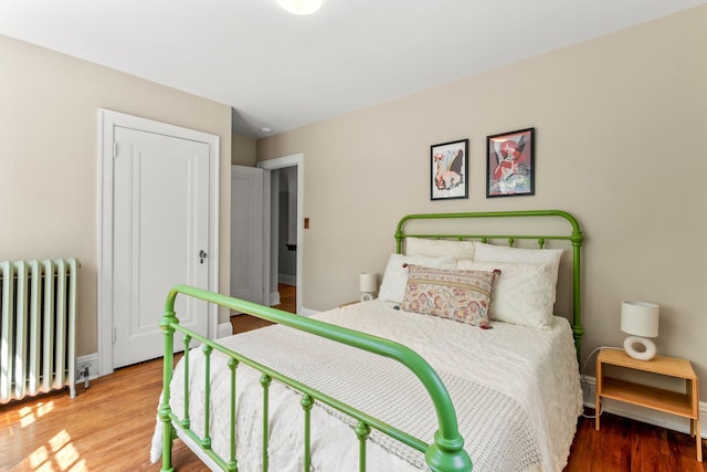 2901 Vincent Ave N, Minneapolis, MN 55411 - bedroom featuring radiator heating unit, wood finished floors, and baseboards