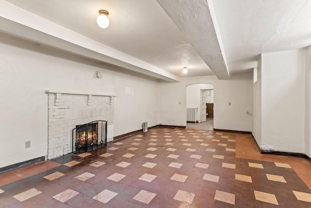 2901 Vincent Ave N, Minneapolis, MN 55411 - below grade area with radiator heating unit, arched walkways, a brick fireplace, and baseboards