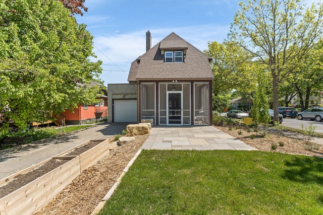 2901 Vincent Ave N, Minneapolis, MN 55411 - rear view of house featuring a sunroom, driveway, a chimney, a yard, and an attached garage