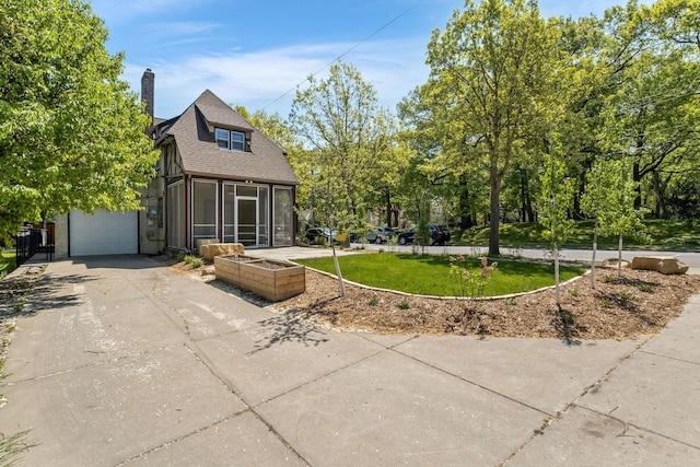 2901 Vincent Ave N, Minneapolis, MN 55411 - rear view of house featuring a sunroom, driveway, a chimney, a garage, and a shingled roof