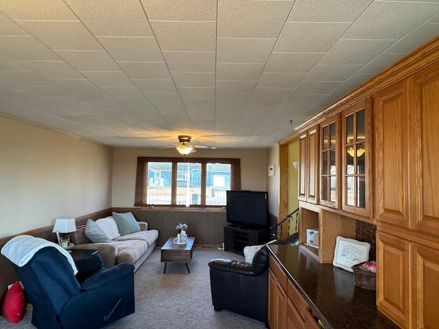 living area featuring ceiling fan and carpet