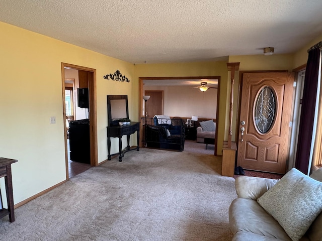 entryway featuring carpet flooring, a textured ceiling, a ceiling fan, and baseboards