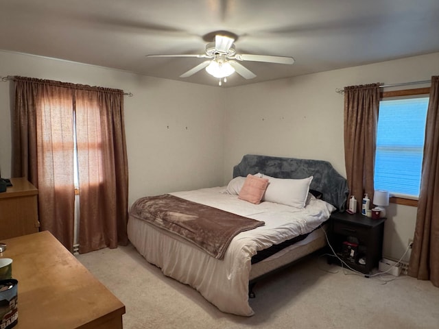 bedroom featuring light colored carpet, multiple windows, and ceiling fan