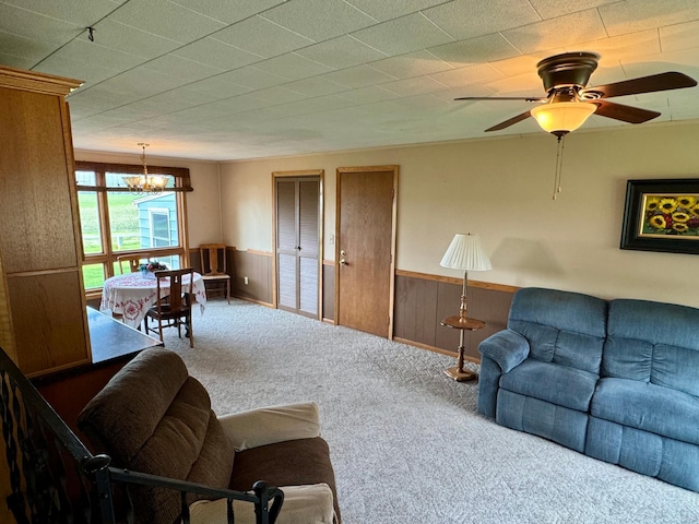 1001 Birch Ave, Olivia, MN 56277 - living room featuring carpet flooring, wainscoting, a chandelier, ceiling fan, and wooden walls