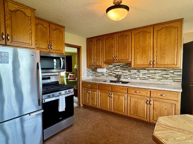 1001 Birch Ave, Olivia, MN 56277 - kitchen featuring stainless steel appliances, a sink, brown cabinetry, light countertops, and tasteful backsplash