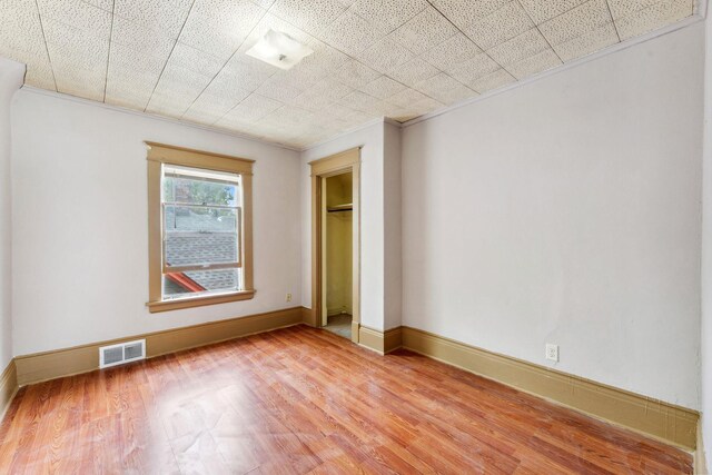 906 5th St E, Saint Paul, MN 55106 - unfurnished bedroom with light wood-type flooring, a closet, crown molding, and baseboards