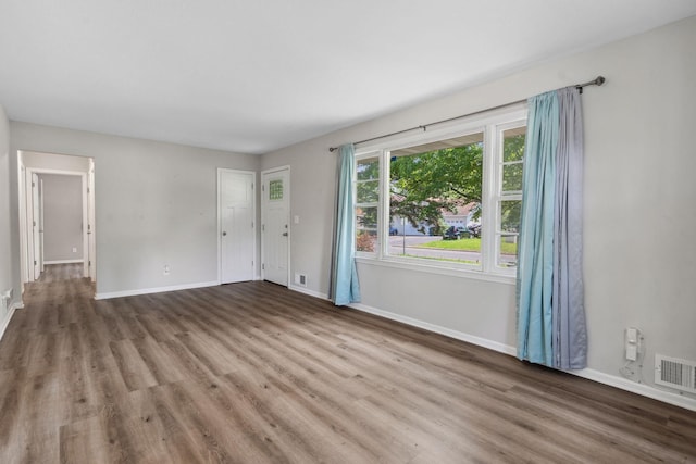 2237 Holloway Ave E, North Saint Paul, MN 55109 - unfurnished living room featuring wood finished floors and baseboards