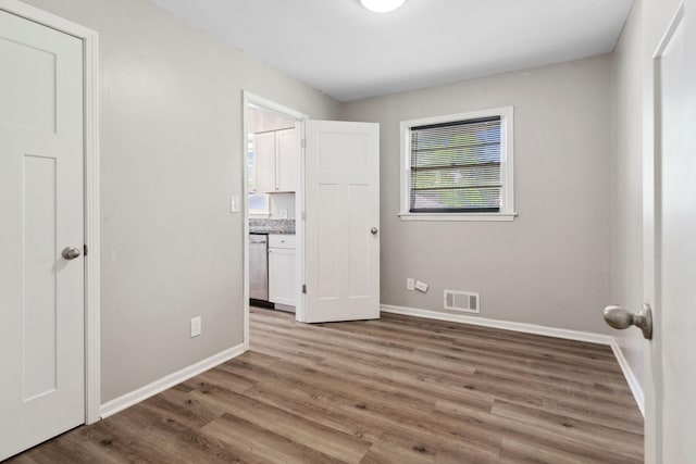 2237 Holloway Ave E, North Saint Paul, MN 55109 - unfurnished bedroom with baseboards and wood finished floors