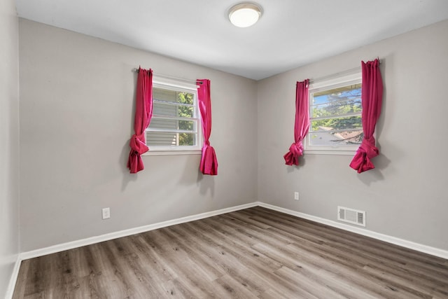 2237 Holloway Ave E, North Saint Paul, MN 55109 - spare room with wood finished floors, plenty of natural light, and baseboards