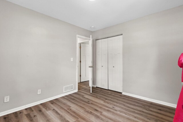 2237 Holloway Ave E, North Saint Paul, MN 55109 - unfurnished bedroom with wood finished floors, baseboards, and a closet