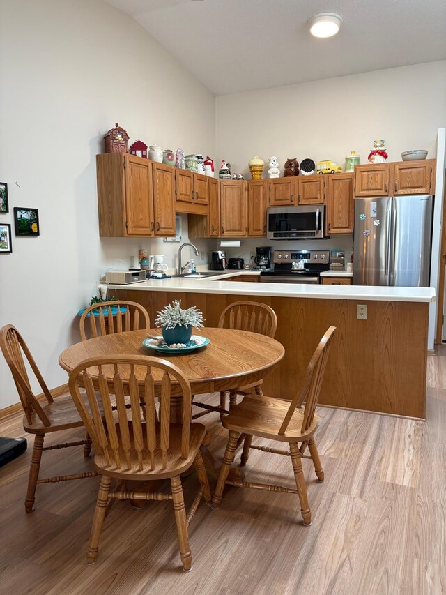 40 Broadway, Plainview, MN 55964 - kitchen featuring stainless steel appliances, light wood-style flooring, light countertops, brown cabinets, and vaulted ceiling