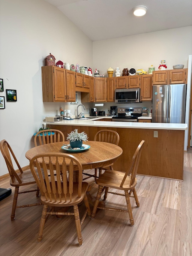 40 Broadway, Plainview, MN 55964 - kitchen featuring stainless steel appliances, light wood-style flooring, light countertops, brown cabinetry, and lofted ceiling