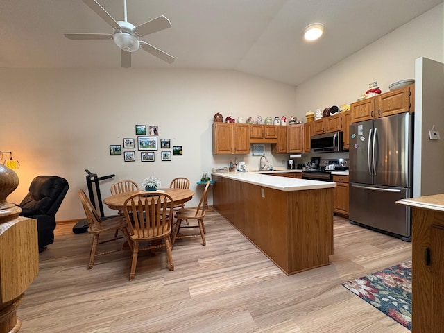 40 Broadway, Plainview, MN 55964 - kitchen featuring appliances with stainless steel finishes, a peninsula, a sink, brown cabinetry, and lofted ceiling