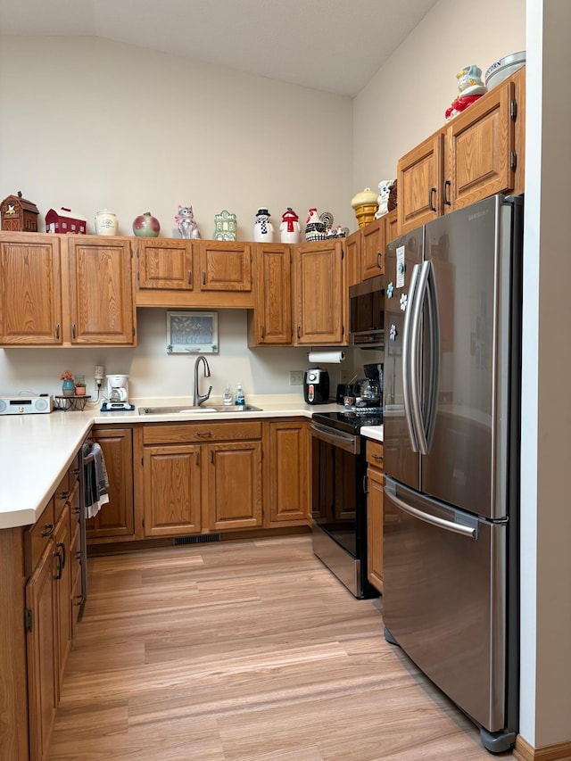 40 Broadway, Plainview, MN 55964 - kitchen featuring appliances with stainless steel finishes, a sink, brown cabinets, light countertops, and light wood-type flooring