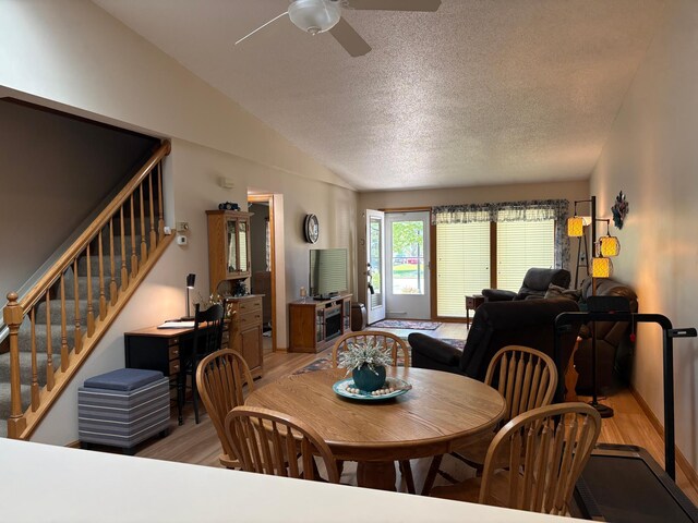 40 Broadway, Plainview, MN 55964 - dining room featuring light wood-type flooring, ceiling fan, stairway, vaulted ceiling, and a textured ceiling