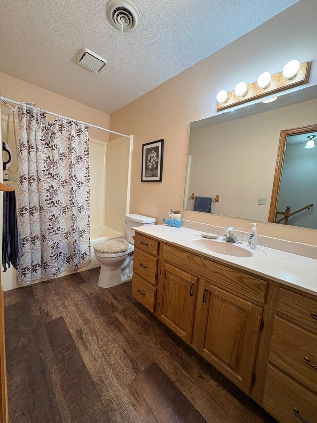 40 Broadway, Plainview, MN 55964 - full bath featuring wood finished floors, shower / bath combo with shower curtain, toilet, vanity, and a textured ceiling