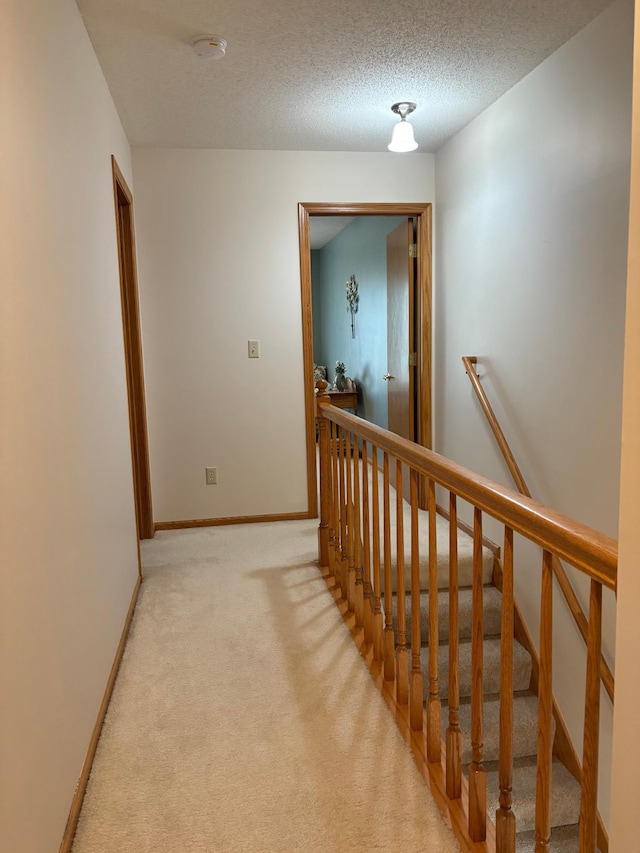 40 Broadway, Plainview, MN 55964 - corridor with an upstairs landing, light colored carpet, baseboards, and a textured ceiling