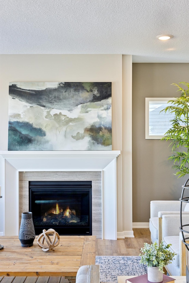 5107 Allen Dr, Woodbury, MN 55129 - detailed view of wood finished floors, a glass covered fireplace, a textured ceiling, and baseboards