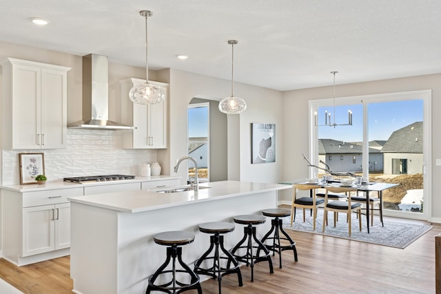5107 Allen Dr, Woodbury, MN 55129 - kitchen with a sink, wall chimney exhaust hood, gas stovetop, light wood-style floors, and backsplash