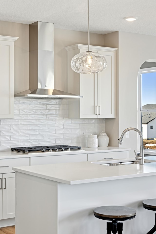 5107 Allen Dr, Woodbury, MN 55129 - kitchen with wall chimney range hood, a sink, light countertops, backsplash, and a textured ceiling
