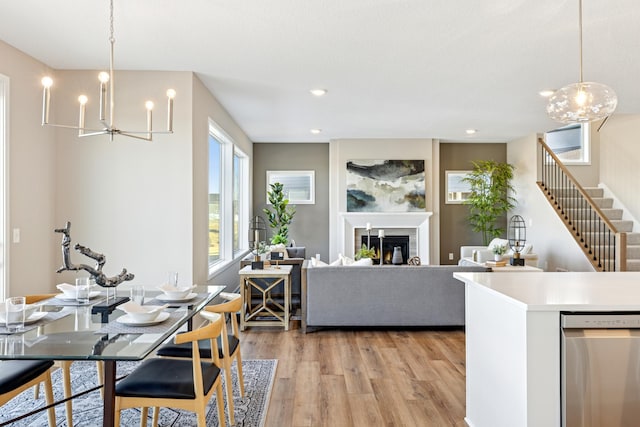 5107 Allen Dr, Woodbury, MN 55129 - dining space with a chandelier, light wood finished floors, stairs, a glass covered fireplace, and recessed lighting