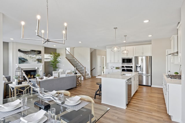 5107 Allen Dr, Woodbury, MN 55129 - kitchen featuring stainless steel appliances, light countertops, a center island with sink, decorative backsplash, and recessed lighting