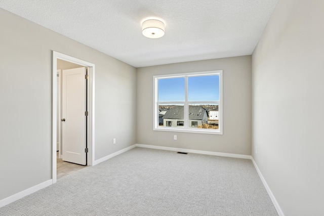 5107 Allen Dr, Woodbury, MN 55129 - unfurnished room featuring light carpet, baseboards, and a textured ceiling