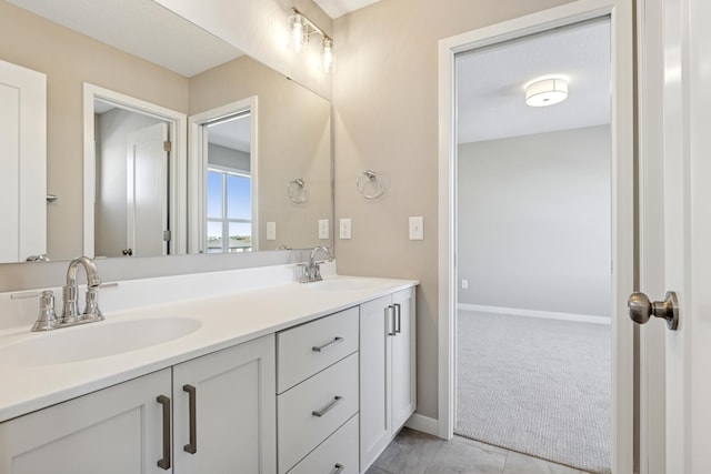 5107 Allen Dr, Woodbury, MN 55129 - bathroom with double vanity, baseboards, and tile patterned floors