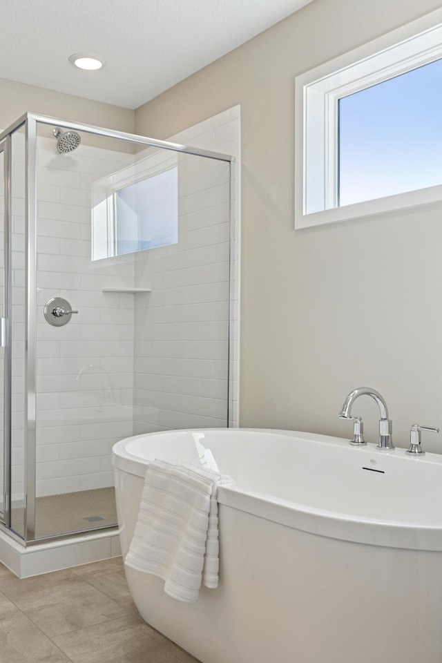 5107 Allen Dr, Woodbury, MN 55129 - full bathroom featuring a stall shower, a freestanding bath, and tile patterned floors