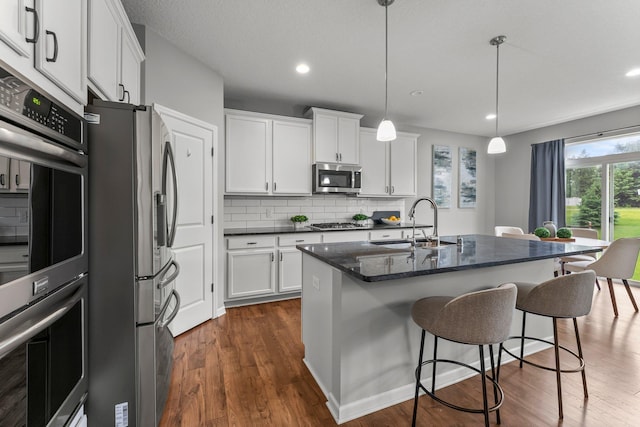 6317 153rd St, Savage, MN 55378 - kitchen featuring a sink, stainless steel appliances, dark wood finished floors, white cabinets, and tasteful backsplash