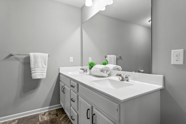 6317 153rd St, Savage, MN 55378 - bathroom featuring double vanity, baseboards, a textured ceiling, and stone finish flooring