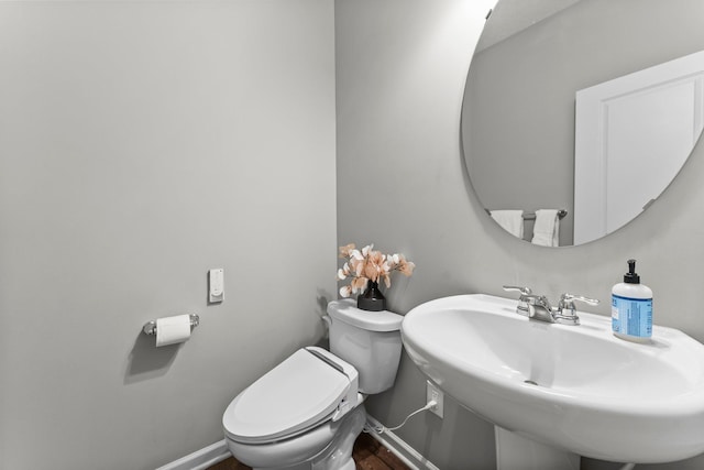 6317 153rd St, Savage, MN 55378 - half bathroom featuring toilet, a sink, wood finished floors, and baseboards