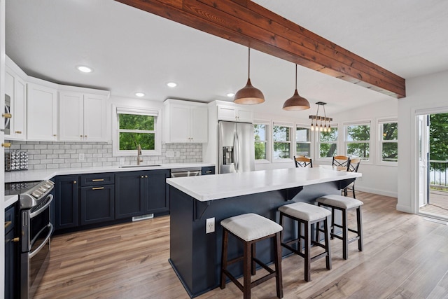 30558 376th Ave, Nordland Twp, MN 56431 - kitchen featuring appliances with stainless steel finishes, a breakfast bar area, backsplash, light wood-type flooring, and beam ceiling