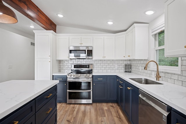 30558 376th Ave, Nordland Twp, MN 56431 - kitchen featuring stainless steel appliances, blue cabinetry, lofted ceiling, white cabinets, and light wood finished floors