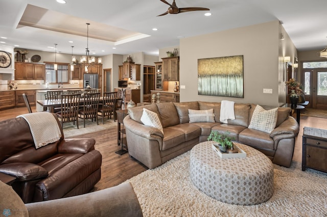 106 Beaton Dr, West Fargo, ND 58078 - living room featuring light wood-style flooring, ceiling fan, a raised ceiling, recessed lighting, and a chandelier