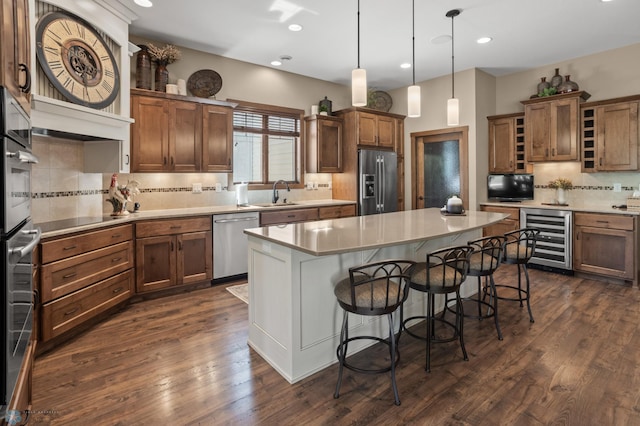 106 Beaton Dr, West Fargo, ND 58078 - kitchen with wine cooler, appliances with stainless steel finishes, a sink, backsplash, and a breakfast bar
