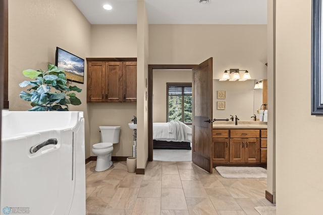 106 Beaton Dr, West Fargo, ND 58078 - ensuite bathroom with toilet, vanity, and baseboards