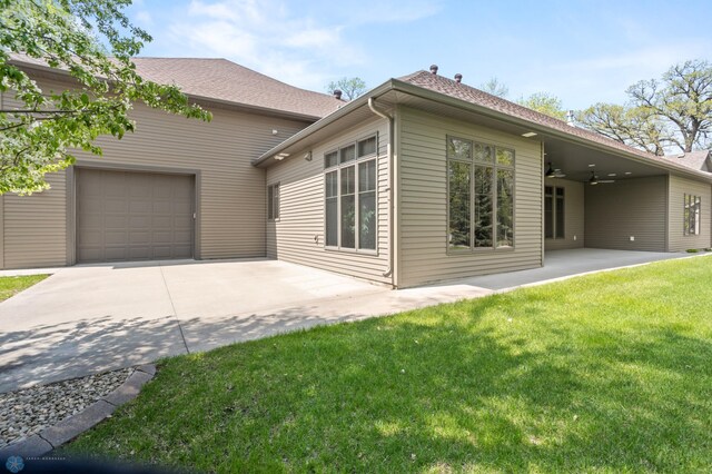 106 Beaton Dr, West Fargo, ND 58078 - rear view of property with a ceiling fan, concrete driveway, a lawn, an attached garage, and a patio