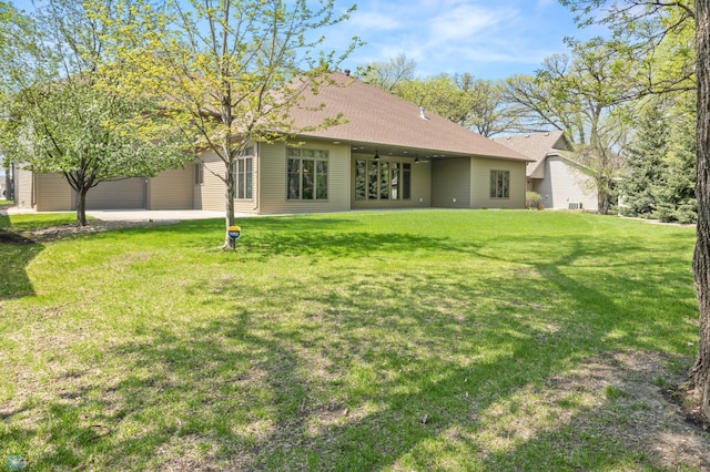 106 Beaton Dr, West Fargo, ND 58078 - rear view of house featuring a yard, a garage, and a shingled roof