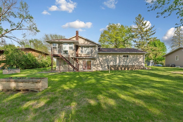 16 Crestview Bay, Faribault, MN 55021 - back of house featuring a sunroom, stairway, a lawn, a garden, and a chimney