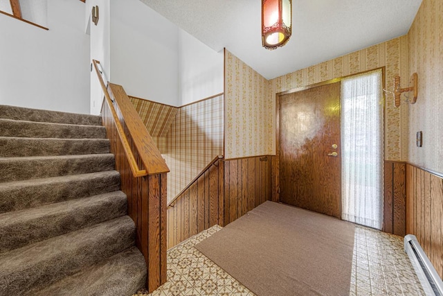 16 Crestview Bay, Faribault, MN 55021 - entryway featuring wainscoting, wallpapered walls, a baseboard radiator, stairway, and wood walls