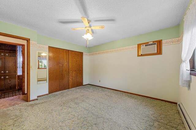 16 Crestview Bay, Faribault, MN 55021 - unfurnished bedroom featuring baseboard heating, carpet, a wall mounted AC, a closet, and a textured ceiling