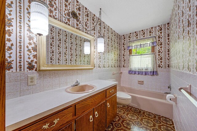 16 Crestview Bay, Faribault, MN 55021 - bathroom featuring tile walls, wallpapered walls, a bathtub, vanity, and toilet