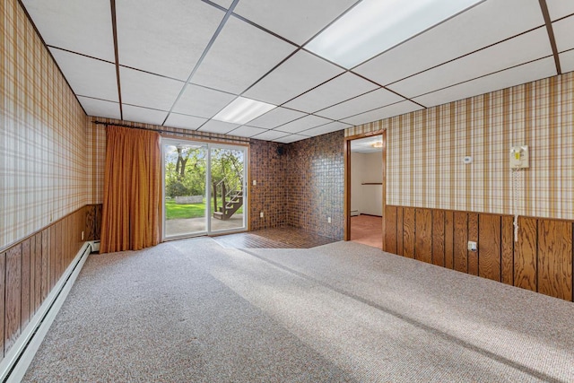 16 Crestview Bay, Faribault, MN 55021 - spare room featuring baseboard heating, wallpapered walls, a wainscoted wall, carpet floors, and a paneled ceiling