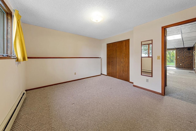 16 Crestview Bay, Faribault, MN 55021 - unfurnished bedroom featuring a baseboard heating unit, carpet, baseboards, a textured ceiling, and a closet