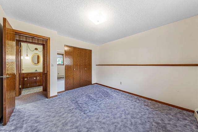 16 Crestview Bay, Faribault, MN 55021 - unfurnished bedroom featuring carpet, a textured ceiling, a closet, baseboards, and connected bathroom