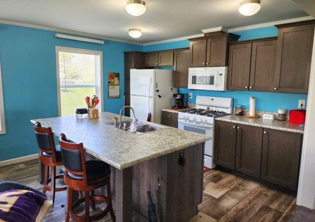 305 4th Ave SW, Milltown, WI 54858 - kitchen featuring white appliances, a sink, dark wood-type flooring, ornamental molding, and an island with sink